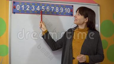 小学教学中女教师站在黑板附近。